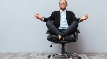 man meditating in office chair symbolizing company wellness program visually