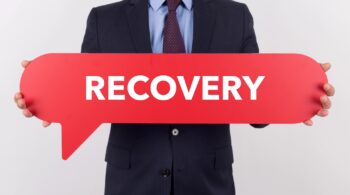 Businessman from a recovery friendly workplace holding speech bubble with a word RECOVERY